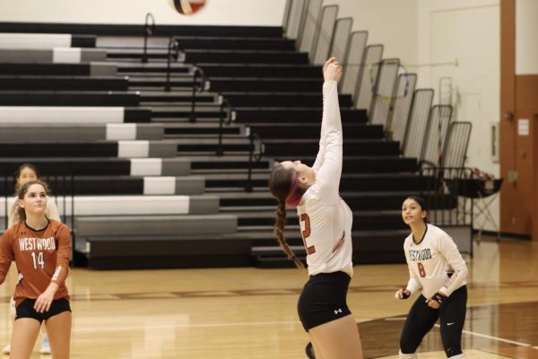 Launching into the air, Outside Hitter Iris Huddleston '28 leaps to deliver the ball on the opposite end of the court. Although the Tigers eventually dominated over the Warriors, Huddleston contributed to the Warrior attempt towards a solid offense. 